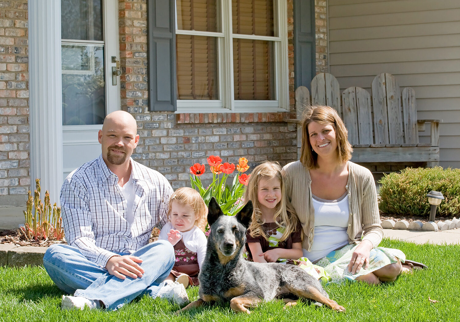 Family Sitting in Front of Their Home